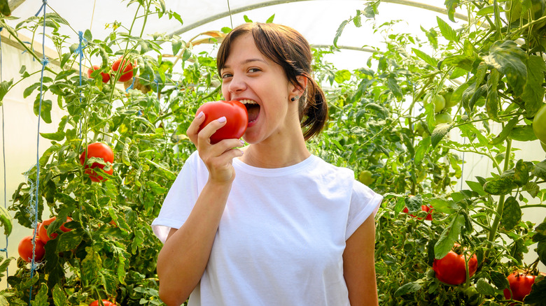 woman biting into a tomato