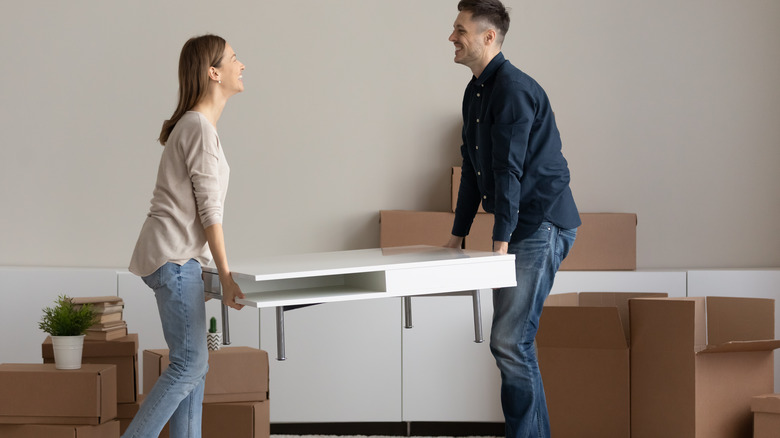 Couple lifting a table