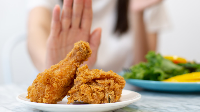 woman rejecting fried chicken