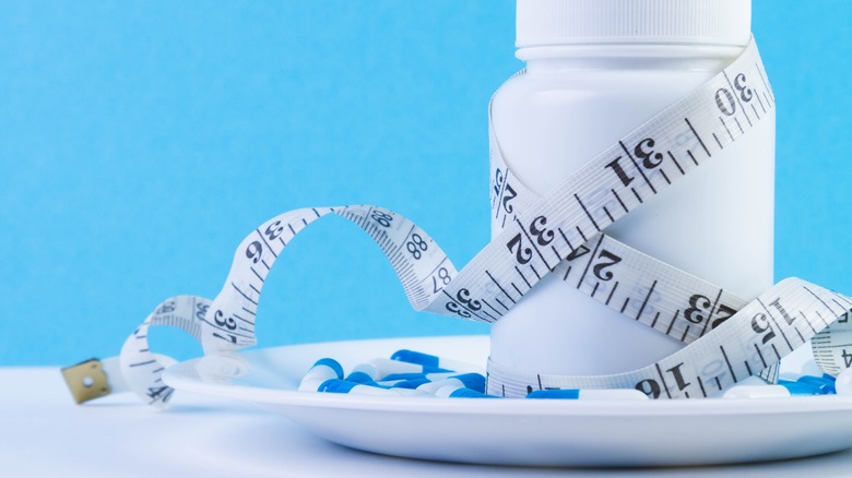 weight loss pills and measuring tape