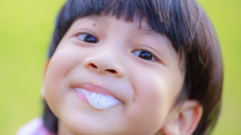 young child with bubbly saliva on lips