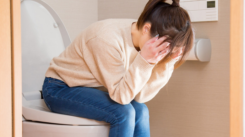 sad woman sitting on toilet