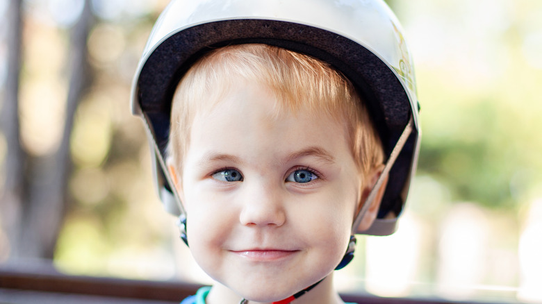 blonde boy wearing bicycle helmet with crossed eyes