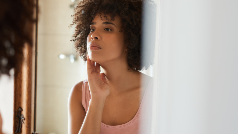 woman looking at herself in a large mirror