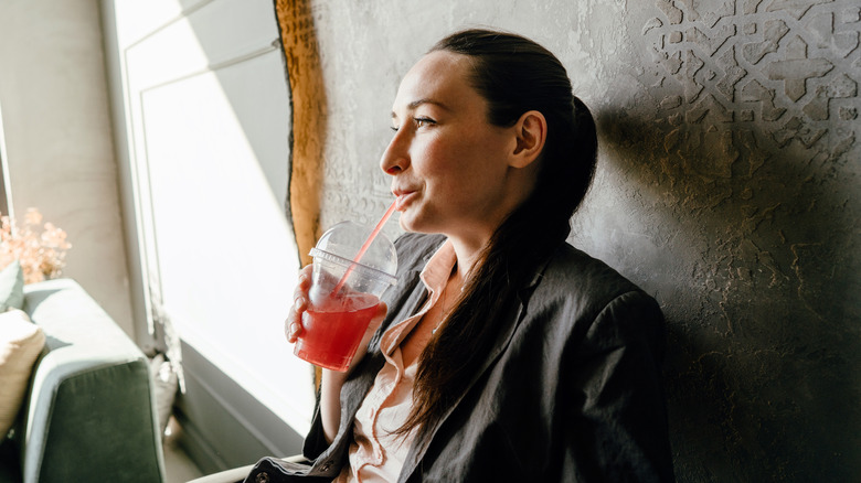 woman drinking red juice