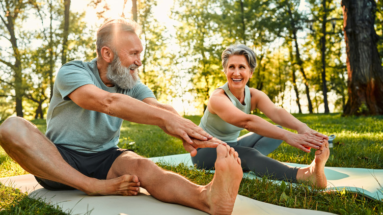 An older couple enjoying stretching outside