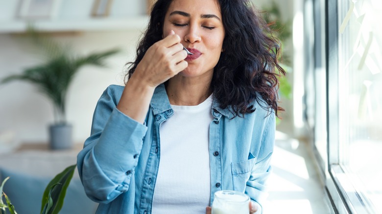 Woman eating yogurt at home