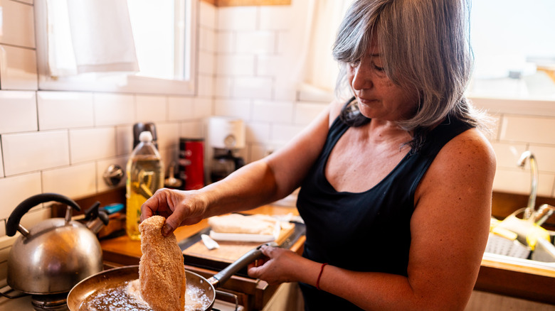 Woman cooking meat at home