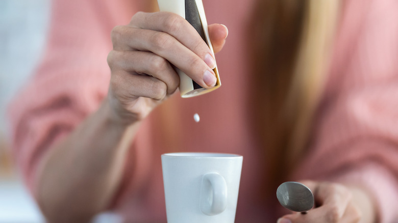 woman using artificial sweetener