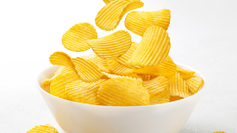 falling potato chips into bowl