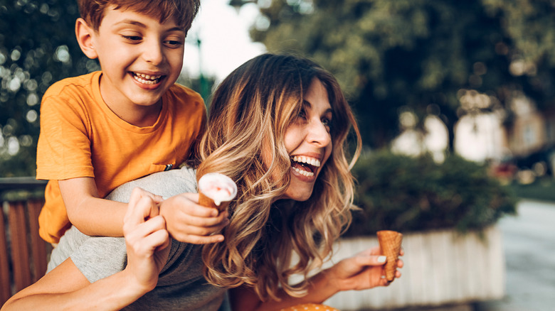 Woman and child are smiling and laughing as they eat ice cream cones