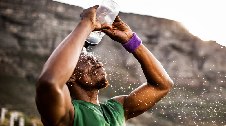 Athlete splashing himself with water to relieve sweating