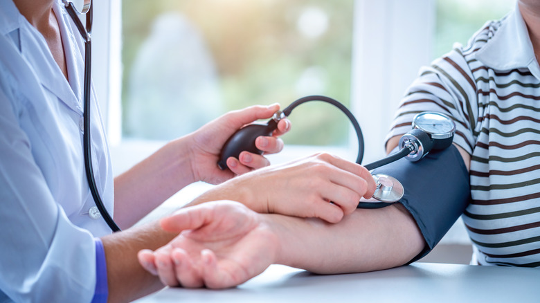 Doctor taking patient's blood pressure