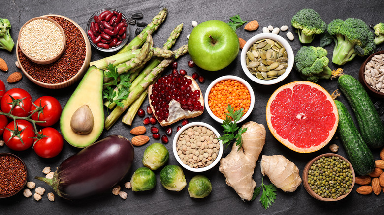 A flat lay of fruits and vegetables against a black background