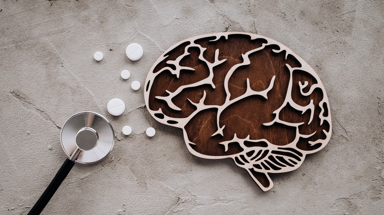 A wood cutout of brain set next to a stethoscope 