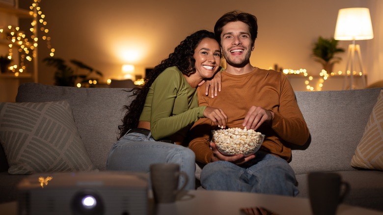 Happy couple eating popcorn together