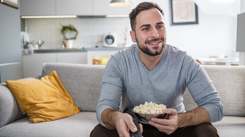 Man smiling and eating popcorn 