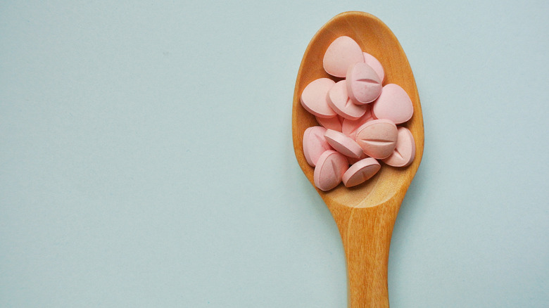 Spoon with vitamin B tablets on it