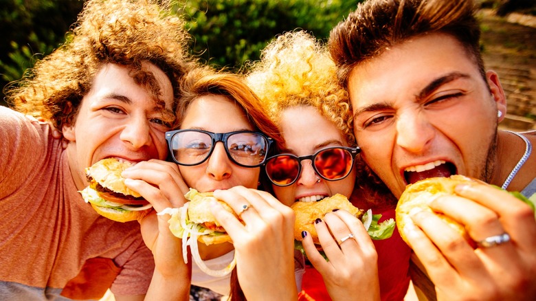 group of friends eating fast food burgers