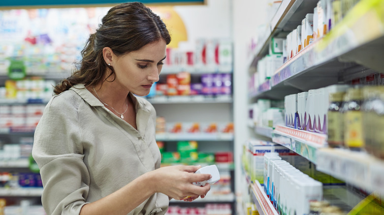 Woman shopping for medication and examining price