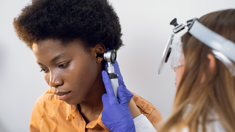 Black female POC getting ear exam