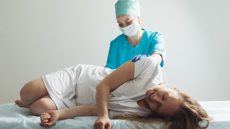 Woman receiving epidural from doctor