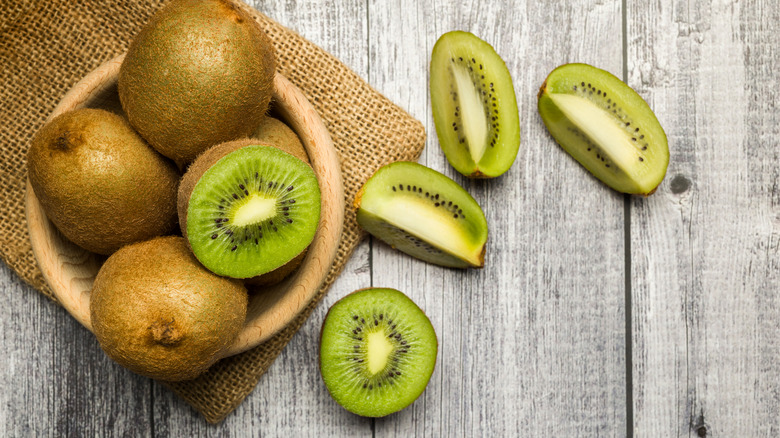 sliced and whole kiwis in a bowl