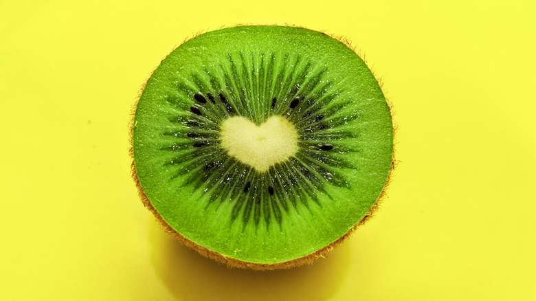 a sliced open kiwi with a heart shaped center 