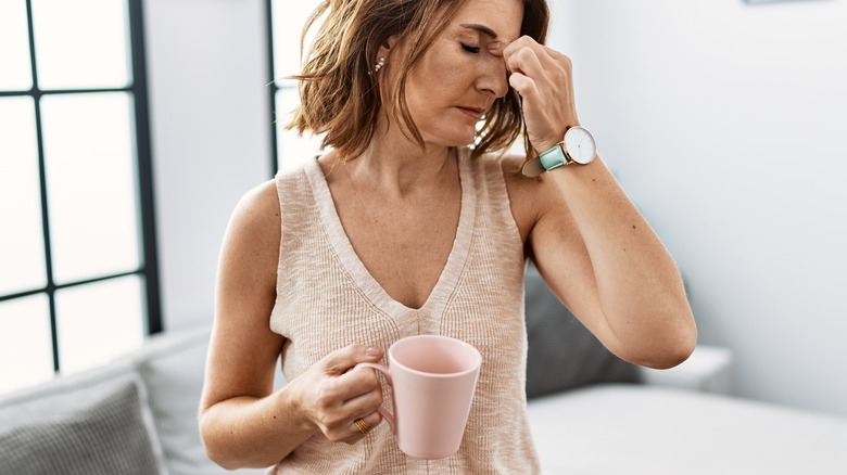 Woman drinking coffee, feeling tired 