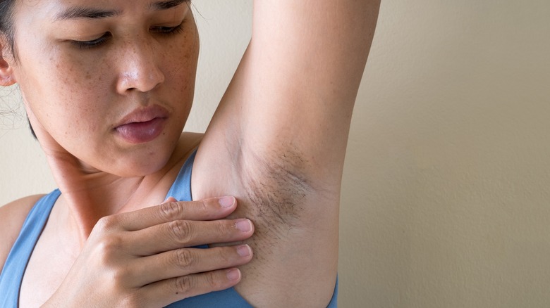 woman inspecting armpit for swelling