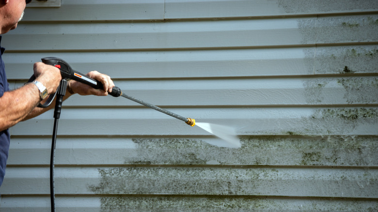 Man power washing garage door