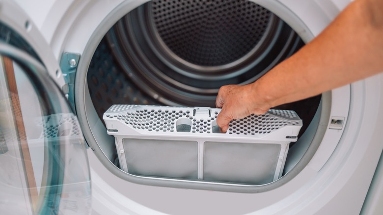 Woman removing the lint trap from dryer