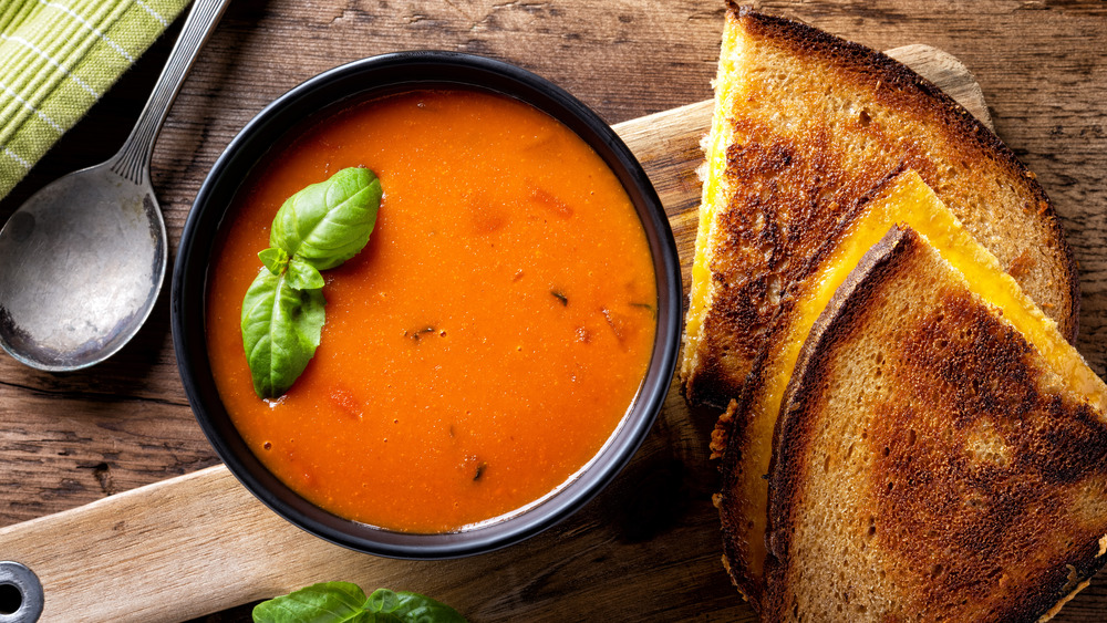 Grilled cheese and tomato soup on a cutting board