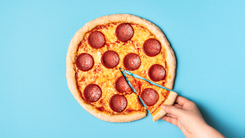 Hand grabbing a slice of pizza