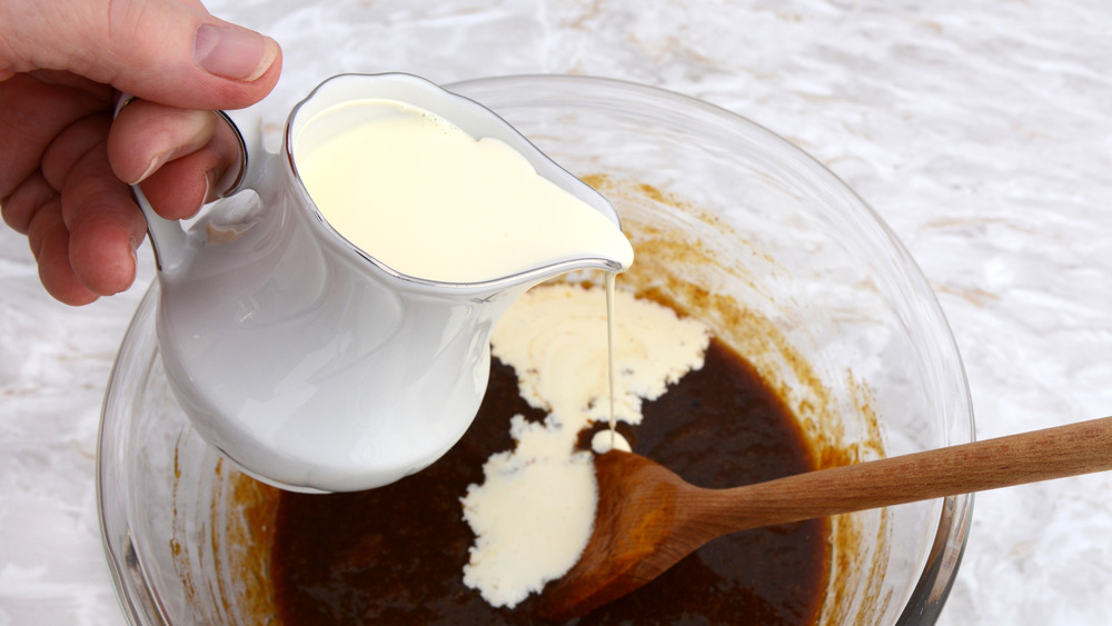 pouring heavy cream into mixing bowl