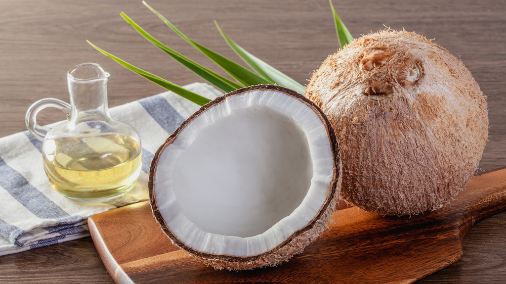 Coconuts with coconut oil on table