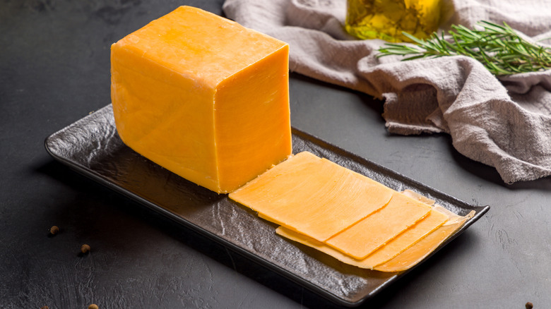 Cheddar cheese sliced on black plate