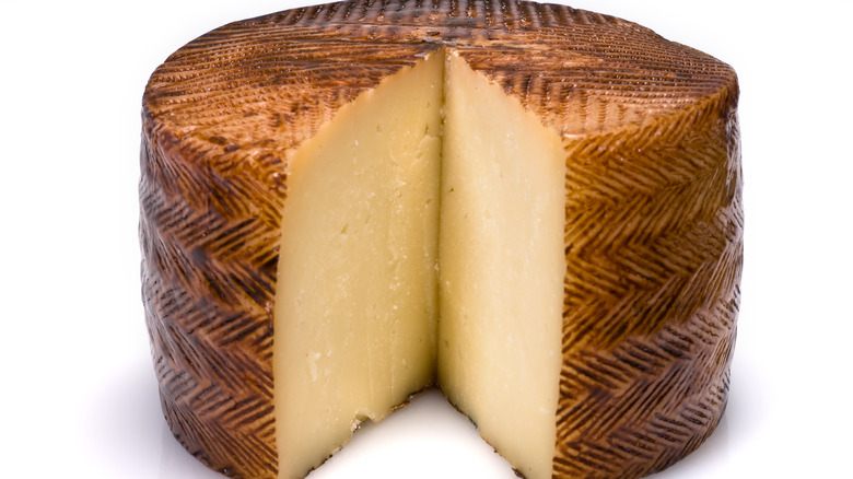 Wheel of Manchego cheese on white background