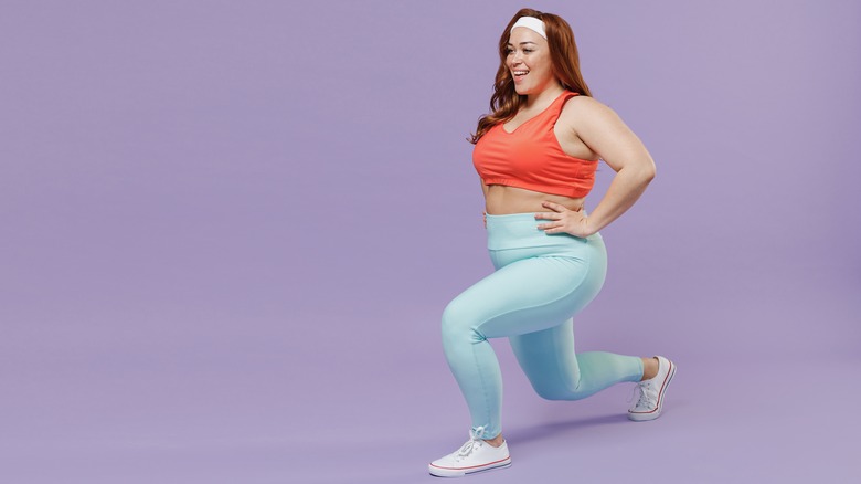 woman smiling while doing a lunge