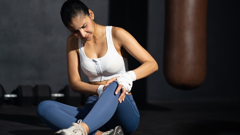 person holding knee in pain after work out