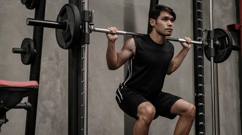 man doing smith machine squat