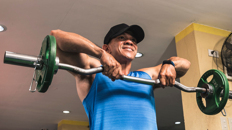 man practicing upright row with barbell weights