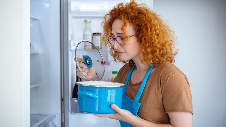 woman smelling something bad in a pot