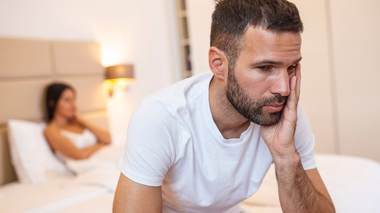 Frustrated couple distant in bed