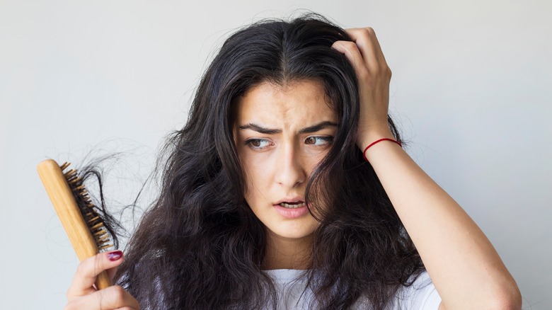 Woman losing hair with brush