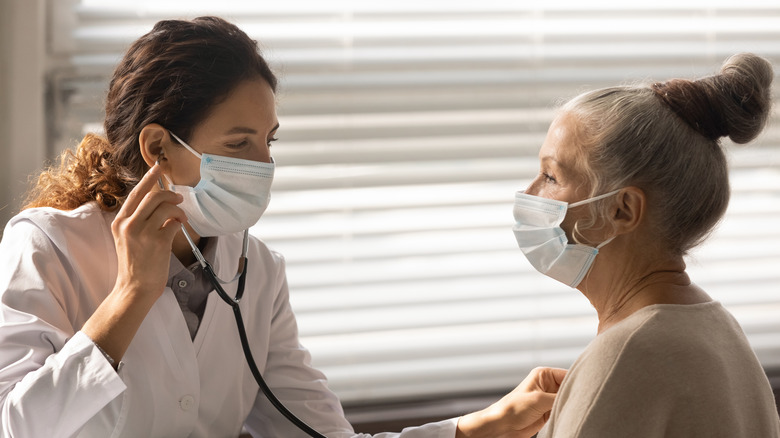 doctor gives elderly patient checkup