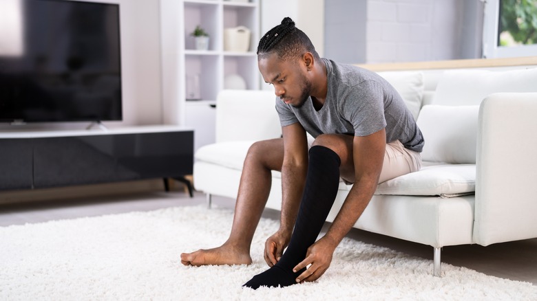 A man putting on compression stockings