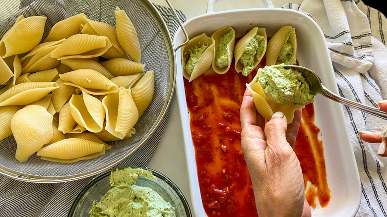 spoon filling shells in dish 