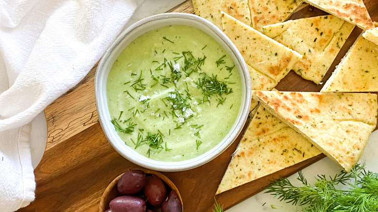 tzatziki in bowl, pita, and olives