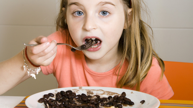 Girl eating black beans